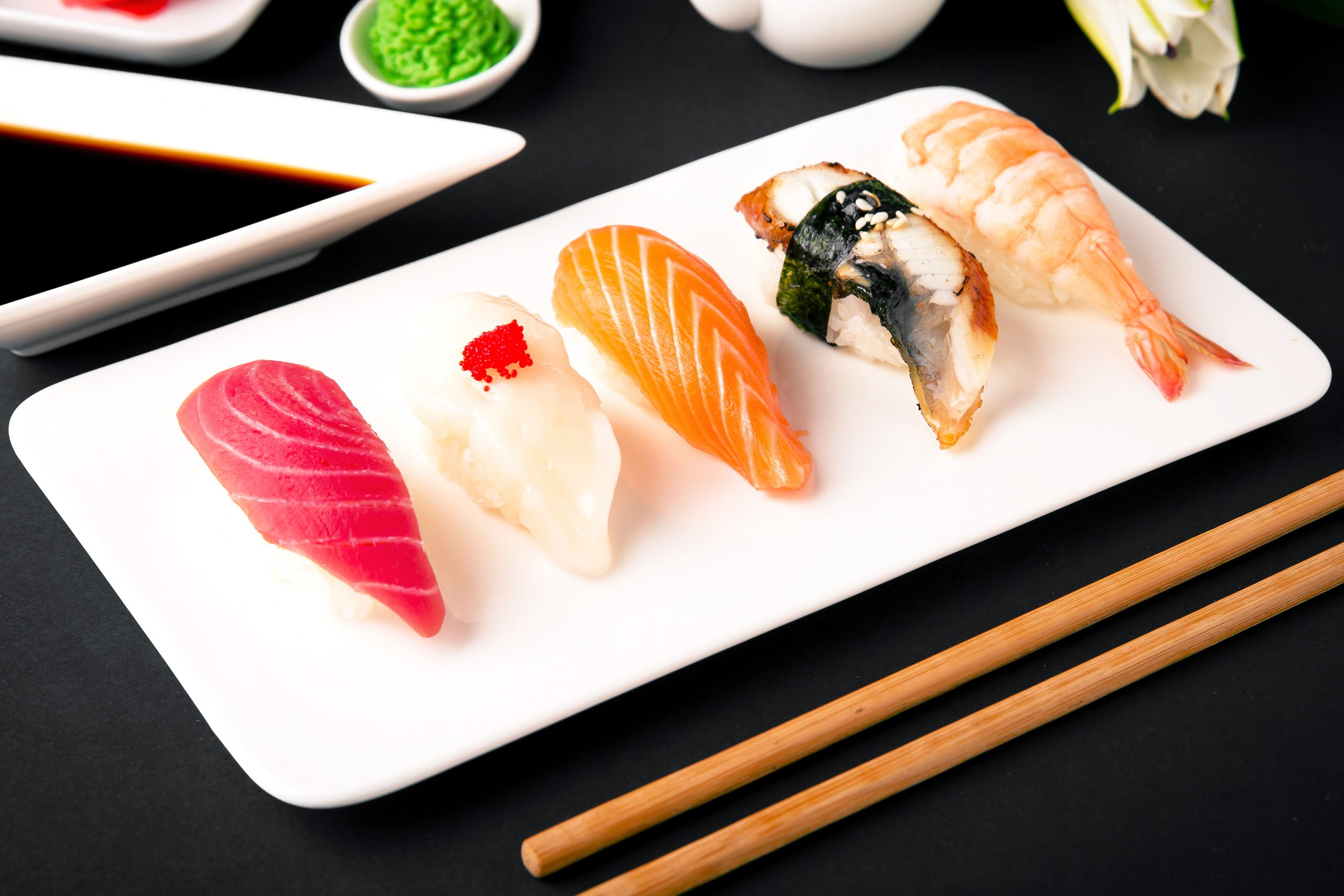 Nigiri with salmon, tuna, perch, eel, scallop, caviar, shrimp, sharp. Gunkan sushi set.   Traditional Japanese cuisine. Black background. Beautiful geometric  food style