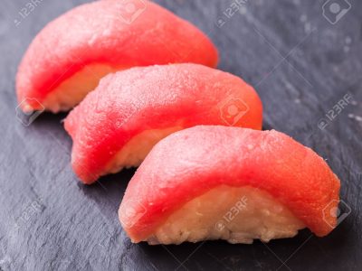 Close-up of Maguro sushi with tuna on a black slate background